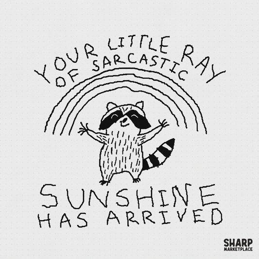 Hand-drawn raccoon with arms wide open under a rainbow with the text Your Little Ray Of Sarcastic Sunshine Has Arrived in a sketch style.
