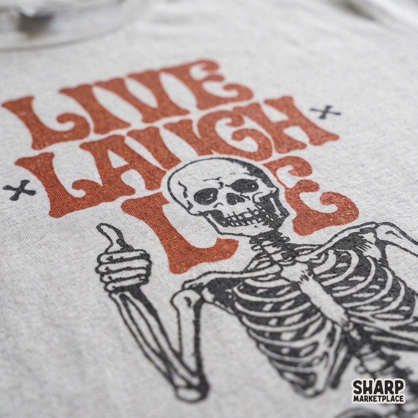 Retro sitting skeleton with sarcastic Live Laugh Die text in a vintage spooky style for Halloween shirts and stickers