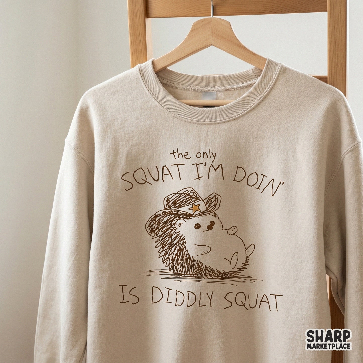 Whimsical hedgehog cowboy illustration with the text The only squat I’m doin’ is diddly squat, ideal for stickers, apparel, and DIY fitness gifts.