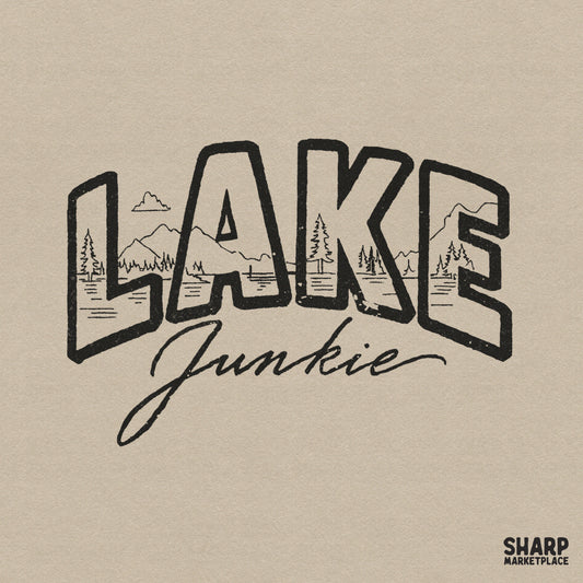 Lake Junkie typography design featuring a mountain and pine tree landscape inside bold block letters with a casual script font for summer apparel.