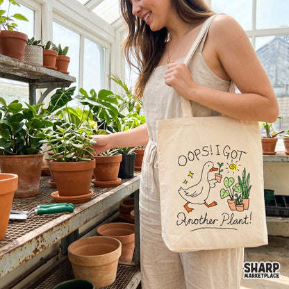 Digital design of a cute goose holding a plant with the quote Oops! I Got Another Plant! surrounded by a sun, stars, and potted greenery.