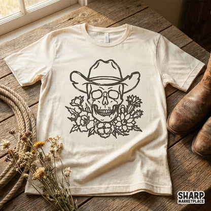 Detailed western skull design with a cowboy hat and desert floral bouquet, shown on a cream-colored t-shirt for a vintage, edgy aesthetic.
