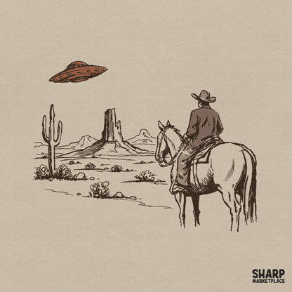 Vintage sketch style digital design of a cowboy on horseback looking at a flying saucer hovering over desert buttes and a saguaro cactus.