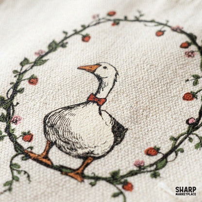 Cute cottagecore goose wearing a red bowtie inside a strawberry wreath for summer sublimation designs
