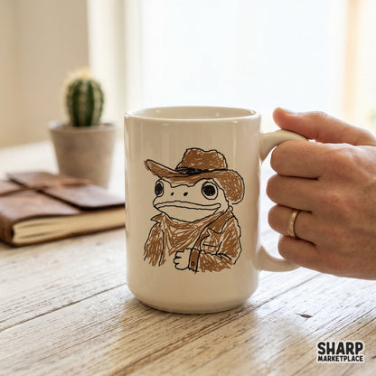 Ceramic coffee mug featuring a cute western frog in a cowboy hat and rancher outfit, rendered in a trendy monochromatic brown ink style.