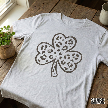 Distressed charcoal grey leopard print shamrock design displayed on a heather grey t-shirt, ideal for trendy St. Patrick's Day clothing and gifts.