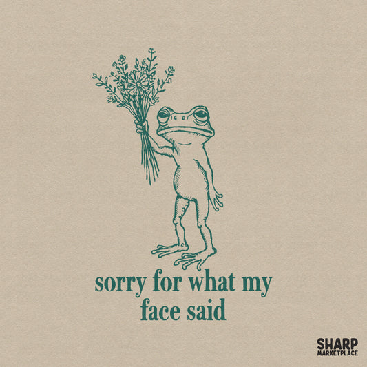 Hand-drawn grumpy frog holding a wildflower bouquet with the text sorry for what my face said in dark green ink for apparel and sublimation projects.