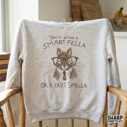 A light heather gray sweatshirt featuring a brown ink sketch of a nerdy squirrel in glasses and a tie with the funny text You're either a SMART FELLA OR A FART