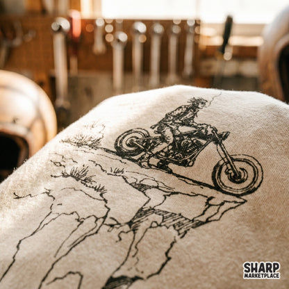 Minimalist black and white sketch of a lone wanderer on a motorcycle at a canyon edge, ideal for custom t-shirts, stickers, and wall art projects.