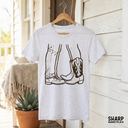 Digital download graphic showing a romantic country couple through their footwear, featuring a lace-up work boot and a decorative cowgirl boot in line art.
