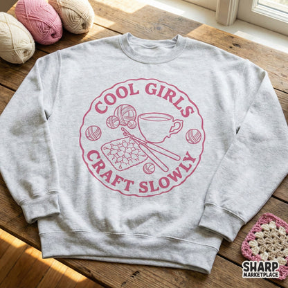 Retro-style dusty rose graphic featuring crochet supplies and coffee, displayed on a light gray crewneck sweatshirt for apparel printing.