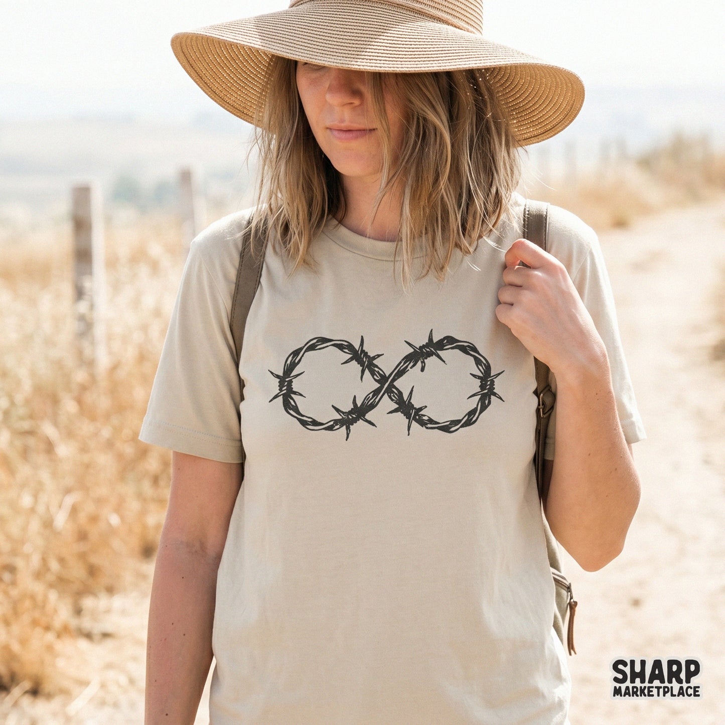 Trendy infinite barbed wire heart graphic printed on a beige t-shirt, showcasing a raw, edgy aesthetic perfect for custom sublimation projects.