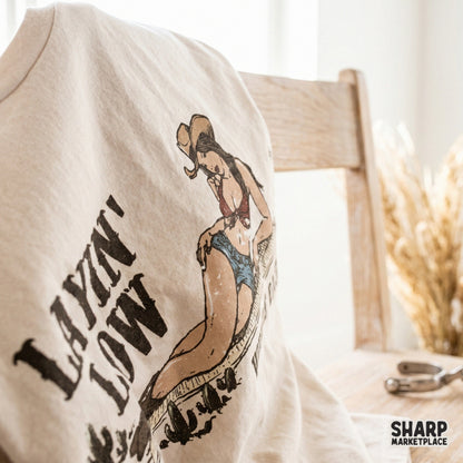 Trendy country style digital graphic for DIY projects featuring a lounging cowgirl and desert cacti, perfect for custom shirts, stickers, or tumblers.