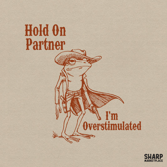 A hand-drawn illustration of a cowboy frog wearing a duster coat and hat, with the text Hold On Partner I'm Overstimulated in a vintage western font.