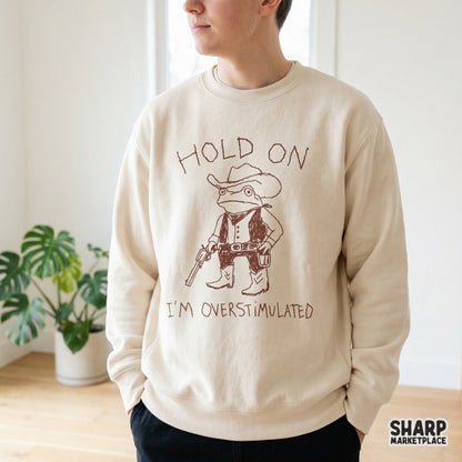 Digital sublimation design featuring a quirky frog cowboy character and the sarcastic phrase Hold On I'm Overstimulated, perfect for custom apparel and