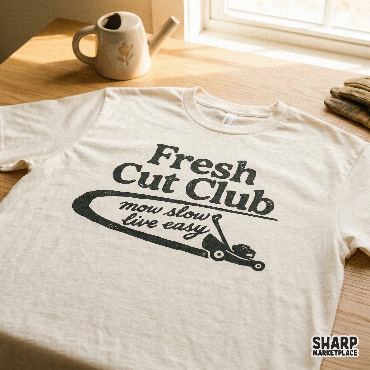 Rustic charcoal-colored Fresh Cut Club graphic featuring a push mower and the phrase mow slow live easy, perfect for custom summer t-shirt prints.