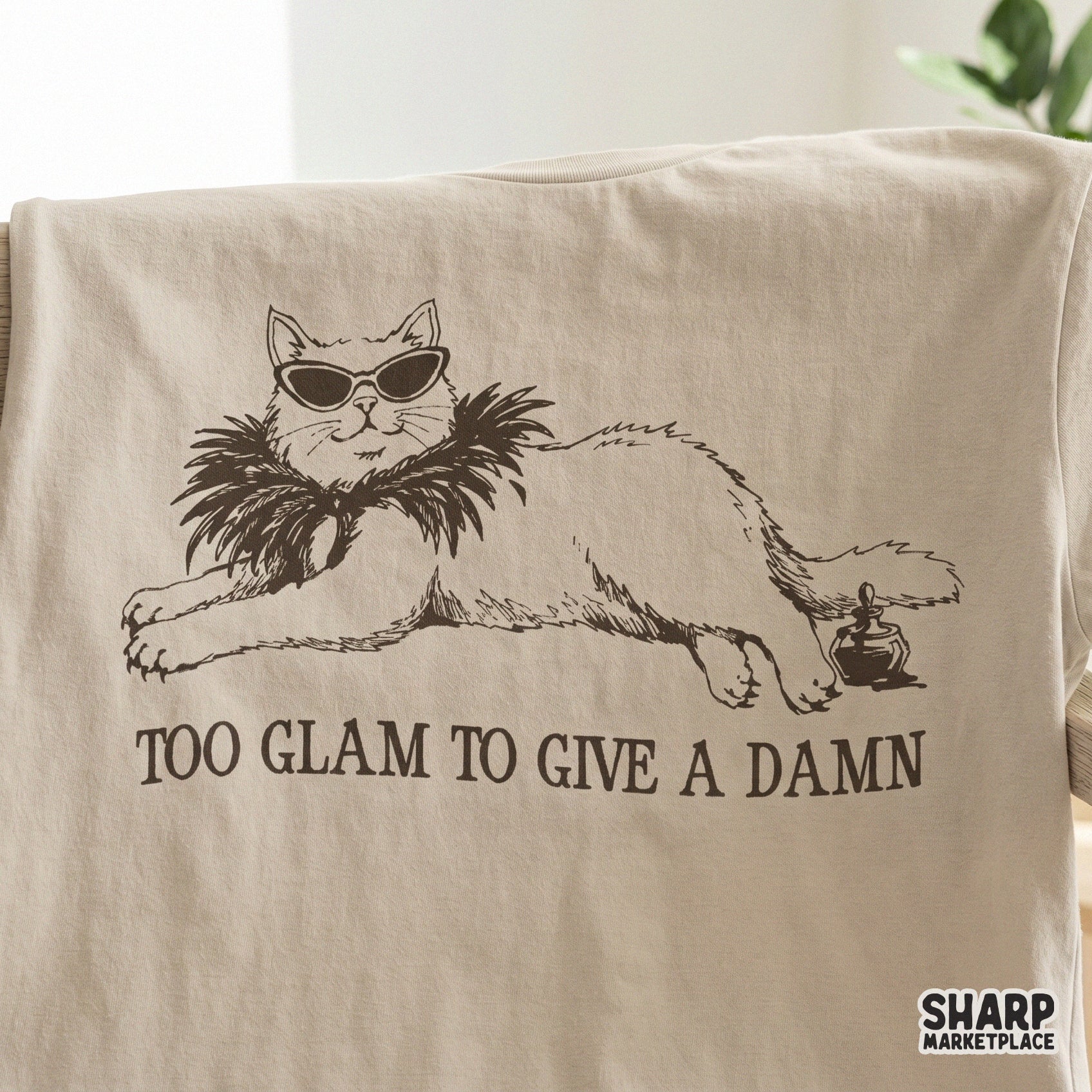 Digital illustration of a glamorous lounging cat with sunglasses and a perfume bottle, featuring the sarcastic quote Too Glam To Give A Damn.