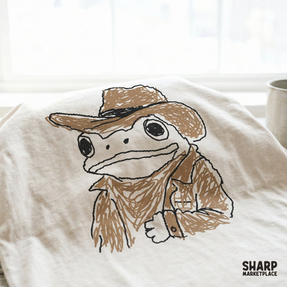 Charming western frog character in a cowboy hat and rancher attire, perfect for rustic country-themed sublimation or apparel designs.