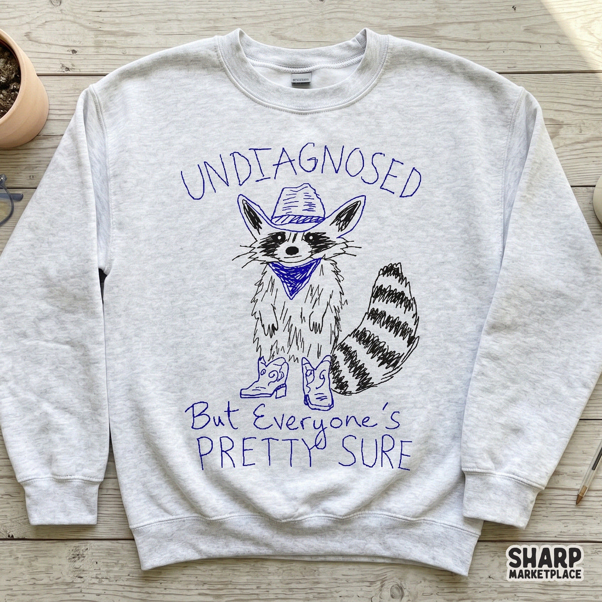 Sublimation-ready graphic of a funny raccoon in western attire with blue text, ideal for custom t-shirts, tumblers, and DIY print projects.