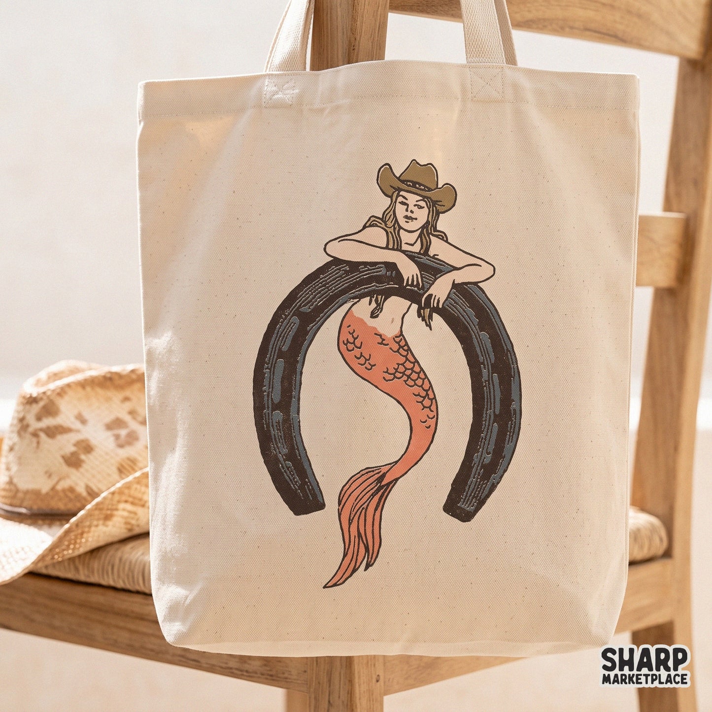 Retro western cowgirl mermaid sitting in a horseshoe design for country music t-shirts and summer beach rodeo apparel