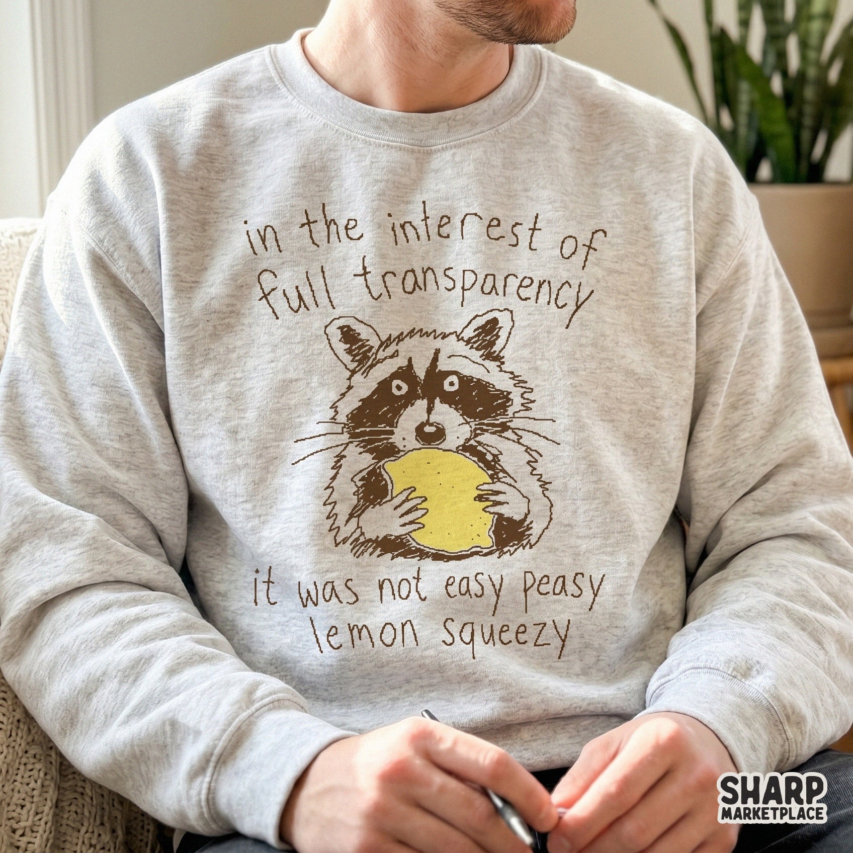 Funny woodland animal graphic featuring a wide-eyed raccoon clutching a lemon, perfect for sarcastic t-shirt sublimation or custom sticker projects.