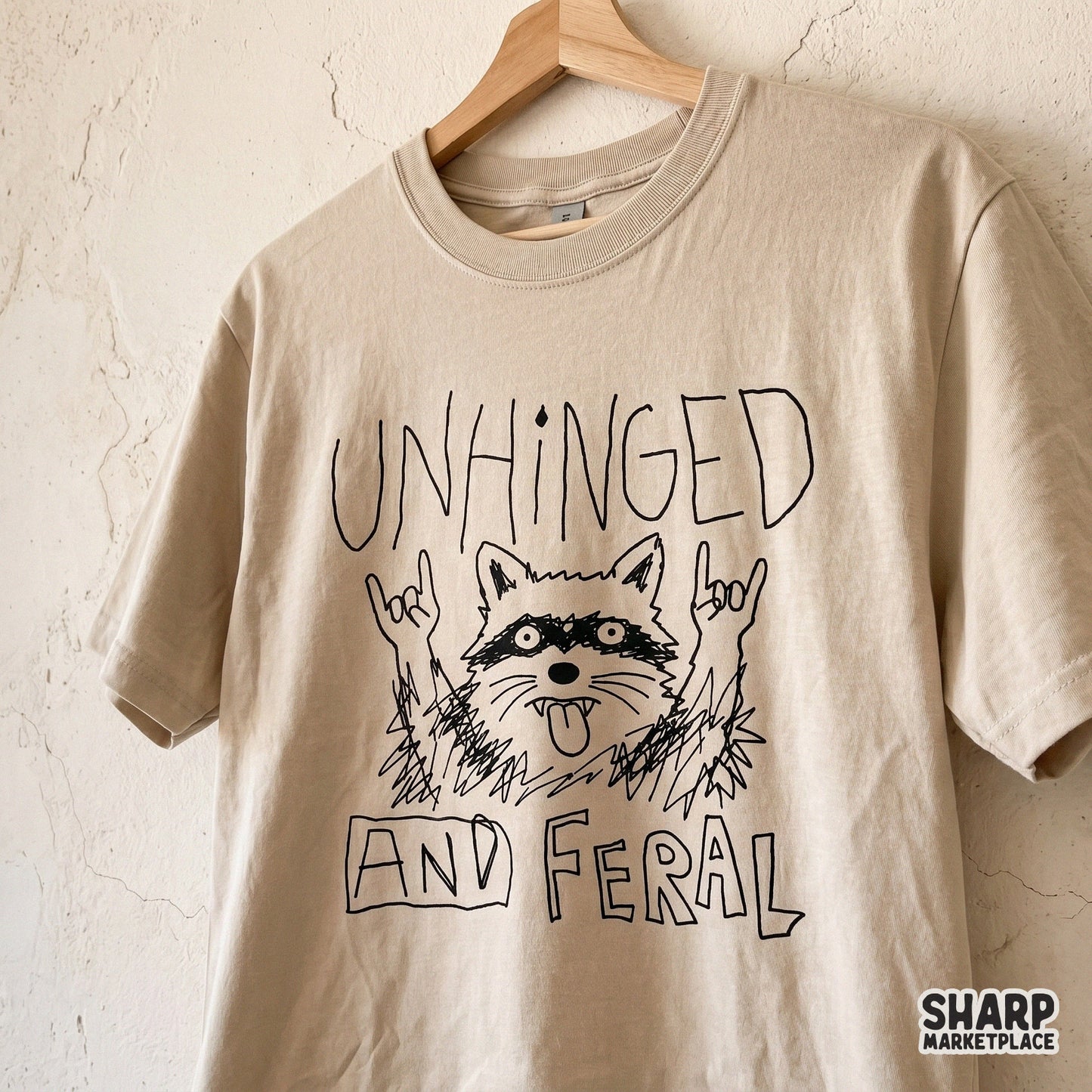 Black and white graphic of a feral raccoon making rock and roll hand signs, designed for sublimation transfers, stickers, and edgy apparel prints.