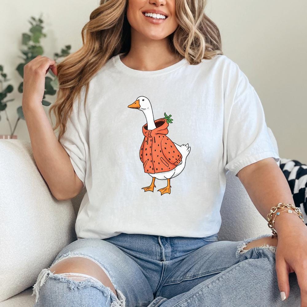 Whimsical animal art featuring a white goose in a strawberry-patterned coat, suitable for coquette-style shirts and custom gifts.