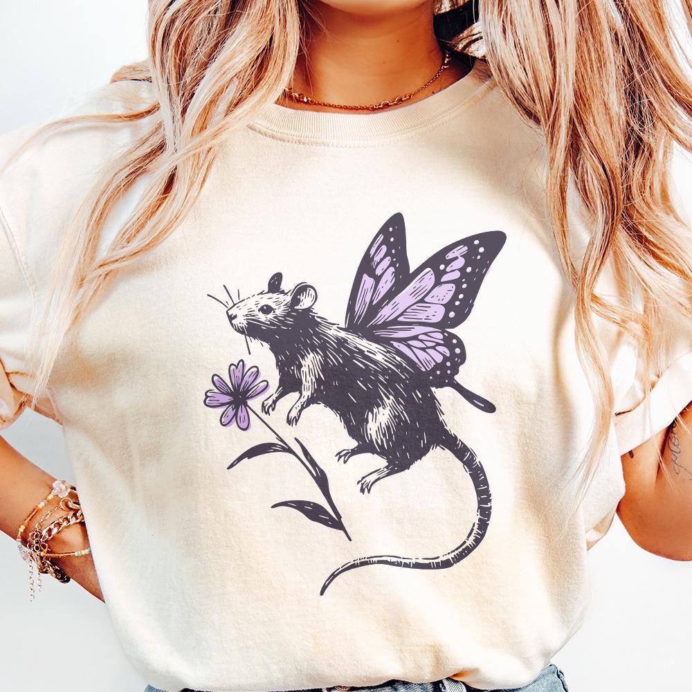 Vintage style fairy rat design featuring detailed butterfly wings and a purple flower, shown printed on a light-colored t-shirt.
